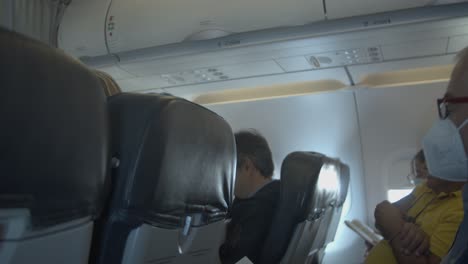 People-on-board-of-airplane-mother-and-child-walking-along-hallway,-day