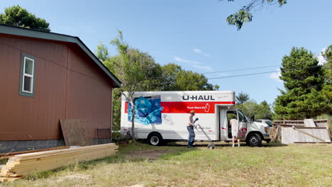 Zwei-Jungs-Packen-Einen-U-Haul-Truck-Aus,-Der-Neben-Einem-Haus-Geparkt-Ist