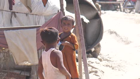 Poor-Young-Girl-Walking-Across-Makeshift-Refugee-Camp-Carrying-Empty-Tin-Can