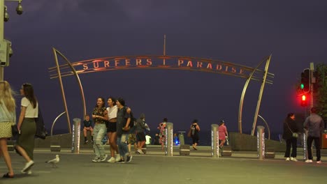 Gente-Paseando-Y-Caminando-Por-La-Explanada-En-Una-Fría-Noche-De-Verano-En-El-Emblemático-Punto-De-Referencia-Del-Paraíso-De-Los-Surfistas,-Costa-Dorada,-Australia