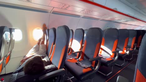 Una-Persona-Durmiendo,-Relajándose-Y-Acostándose-En-Asientos-De-Avión-Easyjet-En-Un-Aeropuerto-Internacional-En-Málaga-España,-Experiencia-De-Vuelo-Easyjet,-Gente-Que-Se-Va-De-Vacaciones,-Toma-De-4k