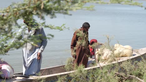 Video-Der-Menschen,-Die-Aus-Dem-Boot-Steigen,-Das-Sie-An-Ihr-Ziel-In-Maher,-Sindh,-Gebracht-Hat