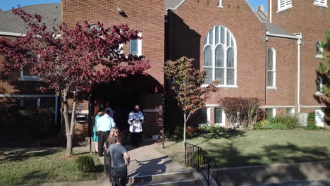 Drone-moves-backward-and-takes-an-aerial-shot-of-the-church-where-people-are-seen-going-inside