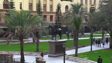 Off-work-daily-commute-peak-hours,-office-workers-rushing-home,-walking-across-Anzac-square-towards-central-station-with-the-scout-sculpture-in-the-center,-Brisbane-city,-central-business-district