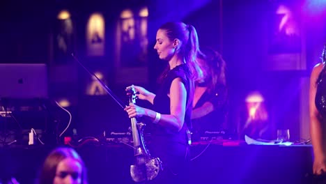 Happy-beautiful-woman-dancing-on-stage-before-playing-with-violin,-static-view-slow-motion