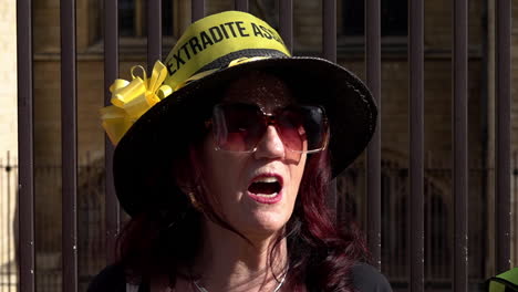 In-slow-motion-a-Julian-Assange-supporter-wears-a-hat-that-reads,-“Don’t-Extradite-Assange”-as-protestors-form-a-human-chain-around-the-Houses-of-Parliament-calling-for-his-release-from-prison