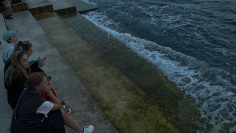 High-angle-view-of-people-sitting-at-sea-organ-steps-in-Zarar-Croatia,-evening