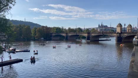 Toma-Manual-De-Botes-A-Pedales-En-El-Río-Vltava-En-Praga-En-Una-Soleada-Tarde-De-Sábado-Con-El-Puente-De-La-Legión-Al-Fondo,-Septiembre-De-2022