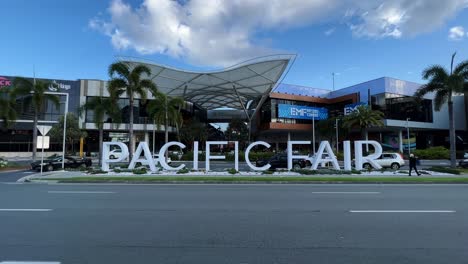 Establishing-static-shot-capturing-the-block-letter-sign-at-the-front-entrance-of-pacific-fair-shopping-centre-against-blue-sky-with-car-traffics-in-the-foreground-on-a-sunny-day