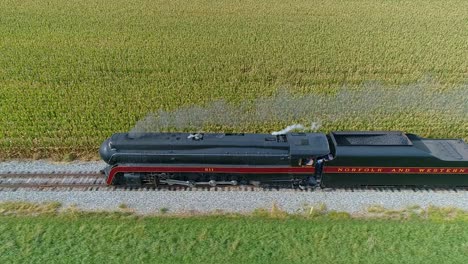 Ronks,-Pennsylvania,-September-25,-2021---Drone-Side-View-of-a-Steam-Locomotive-Traveling-on-a-Single-Track-Thru-Farmlands,-Blowing-Smoke