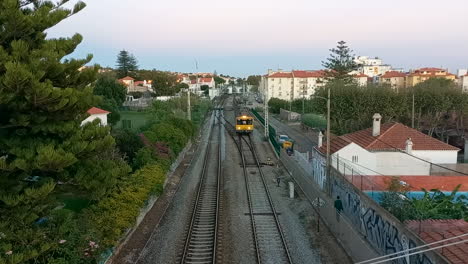 Train-that-passes-on-the-line-through-the-village,-with-houses-and-trees-around,-a-beautiful-architecture