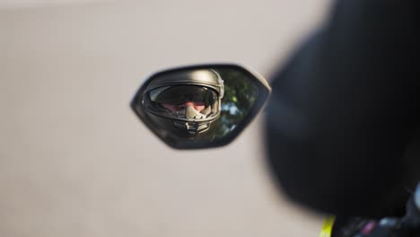 Hombre-En-Motocicleta-Reflejado-En-El-Espejo-Retrovisor-Mientras-Usa-Casco