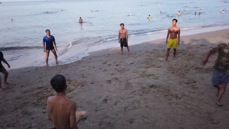 A-group-of-male-Vietnamese-friends-practicing-their-football-or-soccer-skills-on-a-Vietnam-beach-in-early-morning