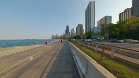 Lapso-De-Tiempo-Del-Paseo-En-Bicicleta-Hacia-El-Sur-En-La-Bicicleta-De-Sendero-Frente-Al-Lago-De-Chicago,-Corriendo-Y-Caminando-Por-El-Sendero-A-Orillas-Del-Lago-Michigan-Oak-Street-Beach-Skyline-Rascacielos