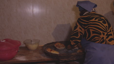 Old-grandmother-hunching-over-delicious-ethnic-baked-goods-that-she's-making