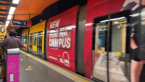 Tranvía-De-Tren-Ligero-Que-Llega-A-La-Estación-De-Cavill-Avenue,-Pasajeros-Que-Embarcan-Y-Viajan-A-Broadbeach-South,-Distrito-Central-De-Gold-Coast,-Queensland,-Australia