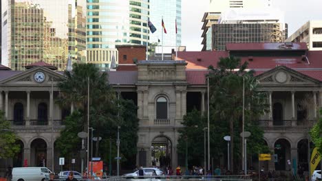 Vorderfassade-Des-Denkmalgeschützten-Australischen-Gebäudes,-Gpo-Von-Brisbane-Im-Belebten-Zentralen-Geschäftsviertel,-Büroangestellte,-Die-Nach-Hause-Eilen,-Durch-Die-Gasse-Gehen,-Autoverkehr,-Der-Auf-Der-Queen-Street-Kreuzt