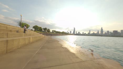 Lapso-De-Tiempo-En-Dirección-Norte-Del-Paseo-En-Bicicleta-Por-El-Sendero-Frente-Al-Lago-De-Chicago,-Desde-El-Planetario-Adler-Hasta-El-Muelle-De-La-Marina,-A-Orillas-Del-Lago-Michigan-Planetario-Adler-Horizonte-De-La-Gran-Ciudad-Bucle-Urbano-Ciclismo-En-El-Centro