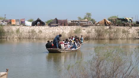 Barco-Abarrotado-Lleno-De-Refugiados-De-Inundaciones-Cruzando-El-Río-En-Mahar,-Sindh