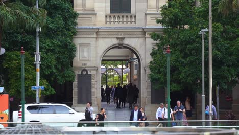 Autoverkehr-überquert-Die-Queen-Street,-Büroangestellte-Gehen-über-Die-Gasse-Im-Denkmalgeschützten-Gebäude-Von-Brisbane-GPO-Australien-Im-Zentralen-Geschäftsviertel-Und-Eilen-Nach-Hause-In-Der-Arbeitsfreien-Zeit