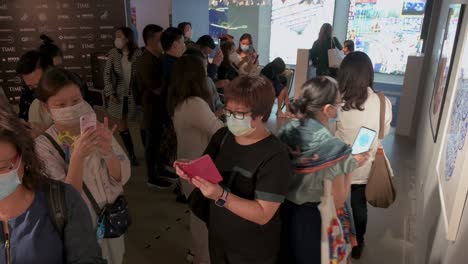 Los-Visitantes-Chinos-Utilizan-La-Realidad-Aumentada-Con-Sus-Teléfonos-Inteligentes-Para-Interactuar-Con-Las-Obras-De-Arte-En-La-Feria-De-Arte-Digital-De-Asia,-Que-Muestra-Las-Próximas-Tendencias,-Como-La-Web-3