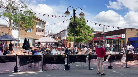 Schwenkansicht-Des-Crawley-Downtown-Square-Mit-Menschen,-Die-An-Sommertagen-Im-Freien-Bier-Trinken,-Vereinigtes-Königreich