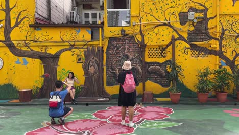 Tourists-take-photos-of-the-beautiful-mural-street-art-painted-in-Changkat-Bukit-Bintang,-Kuala-Lumpur,-Malaysia