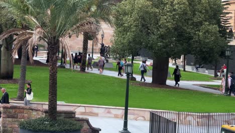 Office-workers-rushing-home-at-5pm,-walking-fast-towards-central-station-across-war-memorial-Anzac-square-at-downtown-Brisbane-city,-central-business-district,-Queensland,-Australia