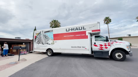 Menschen-Helfen-Beim-Beladen-Eines-U-Haul-Lkw,-Der-Neben-Einem-Haus-In-Einem-Wohngebiet-Geparkt-Ist