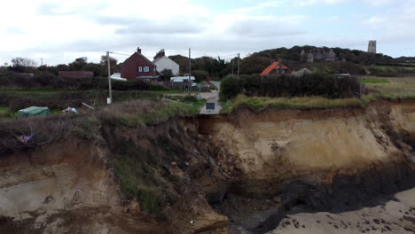 Una-Vista-Aérea-Se-Eleva-Desde-La-Playa-Para-Revelar-Dónde-La-Erosión-Costera-Ha-Destruido-Una-Carretera-Y-Amenaza-Las-Casas-Cercanas-En-La-Costa-De-Norfolk