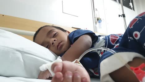 Vista-De-ángulo-Bajo-Del-Niño-Paquistaní-Durmiendo-En-La-Cama-Del-Hospital