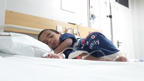 Vista-De-ángulo-Bajo-Del-Niño-Paquistaní-Durmiendo-En-La-Cama-Del-Hospital