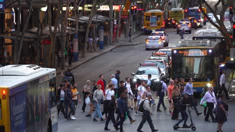 Close-up-shot-capturing-large-crowds-crossing-at-intersection-between-Adelaide-street-and-Edward-street-with-buses-and-cars-waiting-at-traffic-light,-rush-hours-off-work-peak-period,-Brisbane-city