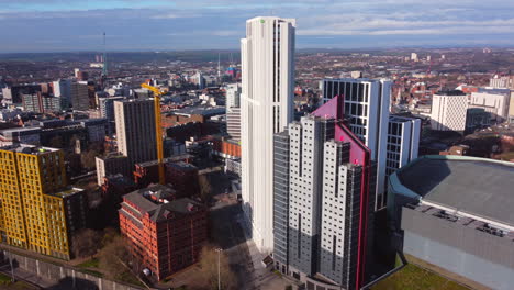 Luftdrohnenaufnahme-Mit-Blick-Auf-Wolkenkratzer-Von-Universitätsunterkünften-Im-Stadtzentrum-Von-Leeds-Mit-Farbenfrohen-Gelben,-Weißen,-Lila,-Orangefarbenen-Gebäuden-Und-Der-Arena-Von-Leeds-In-Der-Nähe-Der-Ringstraße-West-Yorkshire-England-Großbritannien