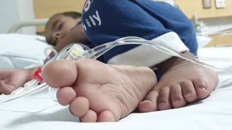 A-critical-ill-Pakistani-boy-sleeping-in-hospital-bed-with-pipes-in-hand