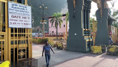 El-Hombre-Sale-De-La-Puerta-Principal-O-Entrada-Del-Famoso-Templo-Hindú-De-Las-Cuevas-De-Batu-En-Selangor,-Kuala-Lumpur,-Malasia