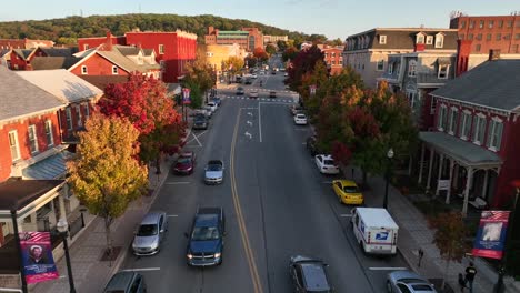 Aerial-tracking-shot-above-traffic-in-autumn-fall-foliage