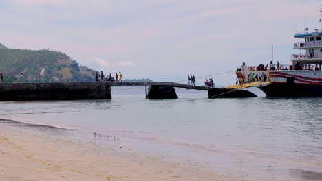 People,-passengers-and-scooters-departing-the-local-ferry-on-remote-tropical-Atauro-Island-from-capital-Dili,-Timor-Leste-in-Southeast-Asia