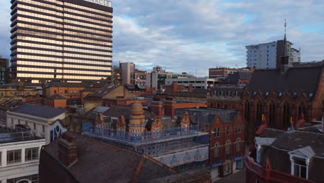 Toma-Aérea-De-Un-Dron-Que-Se-Desplaza-A-Baja-Altura-Sobre-Los-Edificios-Del-Centro-De-La-Ciudad-De-Leeds-Y-El-Edificio-Pinnacle-En-Una-Mañana-Soleada