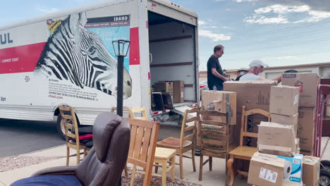 Moving-boxes-and-furniture-piled-up-in-a-driveway