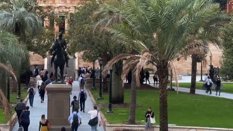 Toma-De-Lapso-De-Tiempo-Que-Captura-A-Un-Gran-Grupo-De-Trabajadores-De-Cuello-Blanco-Que-Salen-Corriendo-A-Casa-A-Las-5-P.-M.-En-El-Centro-Conmemorativo-De-La-Plaza-Anzac,-Ciudad-De-Brisbane,-Queensland,-Australia