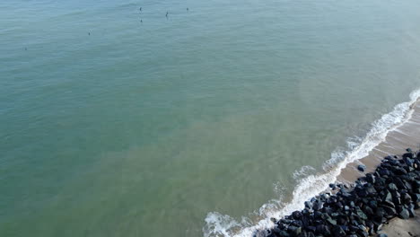 Eine-Luftaufnahme-Alter-Baulicher-überreste,-Die-Aus-Der-Nordsee-Herausragen,-Und-Meeresverteidigungen,-Die-Die-Küste-Des-Dorfes-Happisburgh-Vor-Küstenerosion-An-Der-Küste-Von-Norfolk-Schützen