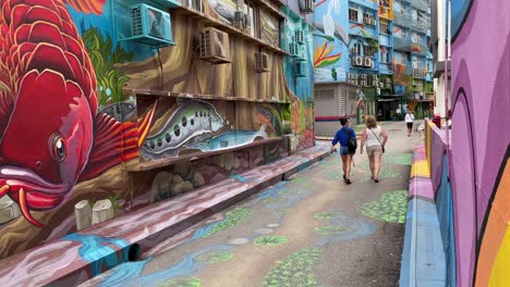 Tourists-admire-the-beautiful-mural-street-art-painted-in-Changkat-Bukit-Bintang,-Kuala-Lumpur,-Malaysia