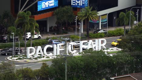 Close-up-shot-of-front-entrance-of-pacific-fairs-shopping-centre,-static-shot-capturing-car-driving-at-the-gated-roundabout-exit-to-Hooker-Blvd,-Broadbeach,-Gold-Coast,-Queensland,-Australia