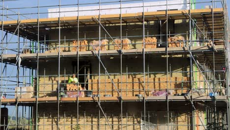 Brick-laying-construction-time-lapse-with-worker-building-the-exterior-facade-of-new-home-in-PUUR21-urban-development-real-estate-project