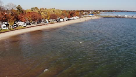 Una-Vista-Aérea-De-Otoño-De-Un-Parque-De-Casas-Rodantes-En-La-Costa-Del-Lago-Huron-En-La-Ciudad-De-Tawas,-Michigan