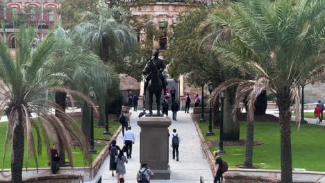 5pm-peak-hours,-office-workers-rushing-home,-walking-fast-across-Anzac-square-towards-central-station-to-catch-a-train-at-downtown-Brisbane-city,-central-business-district,-Queensland,-Australia