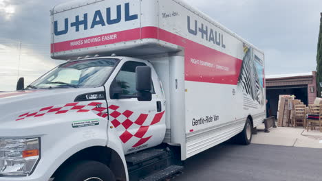 Großer-U-Haul-Truck-Vor-Einem-Haus-Mit-Offener-Garage