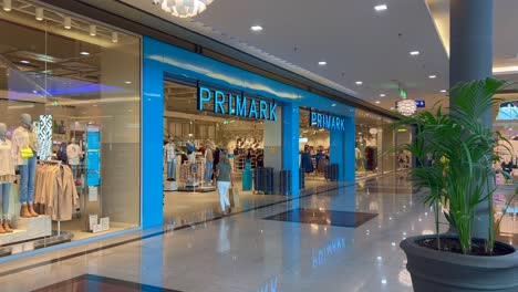 Storefront-of-Primark,-famous-fast-fashion-chain-at-La-Canada-shopping-mall-in-Marbella-Spain,-people-walking-around-and-shopping,-4K-shot