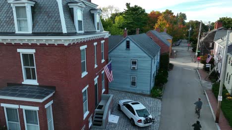 People-ride-bike-in-historic-New-England-residential-district-during-autumn